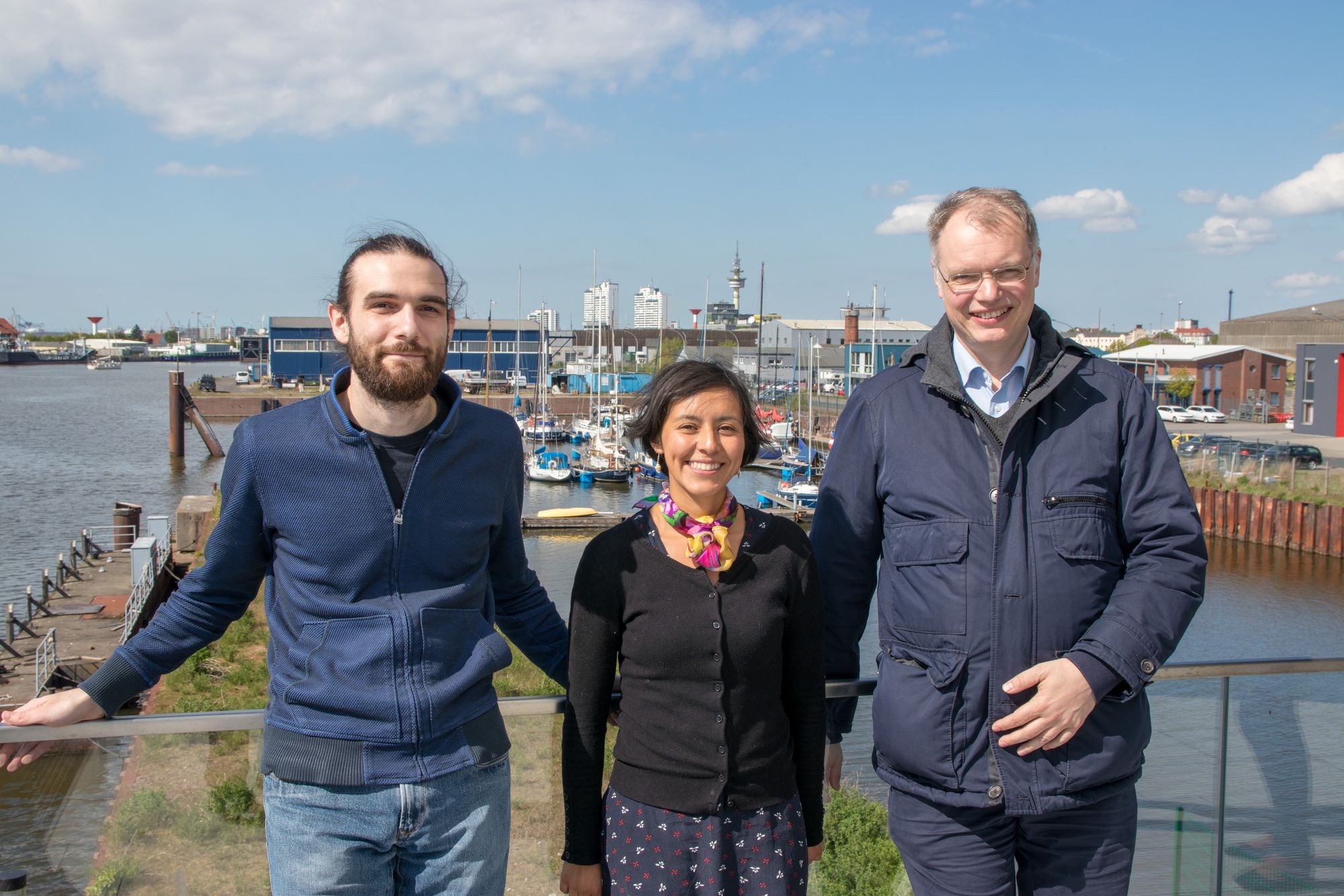 Mitarbeiter, Mitarbeiterin und Leiter des Arbeitspakets 2 vor dem Bremerhavener Hafen